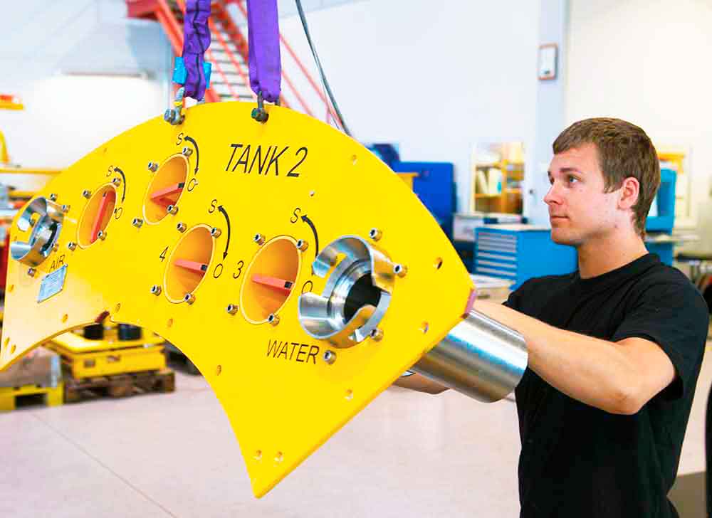 A male employee in Depro moves a control panel in Depro's workshop.