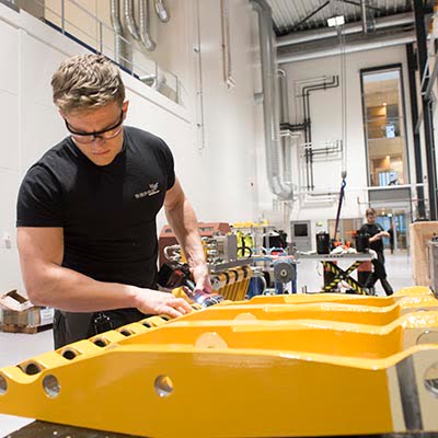 Man working with subsea pipehandler in Depro's workshop hall