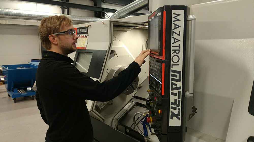 Male employee at Depro AS works at a CNC machine.